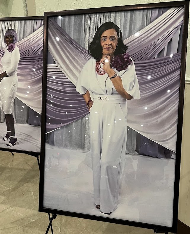 Framed portrait of Senior Pastor Patty Lynn Smith Kemp in a white jumpsuit with a plum flower; Winifred Smith's portrait stands at left